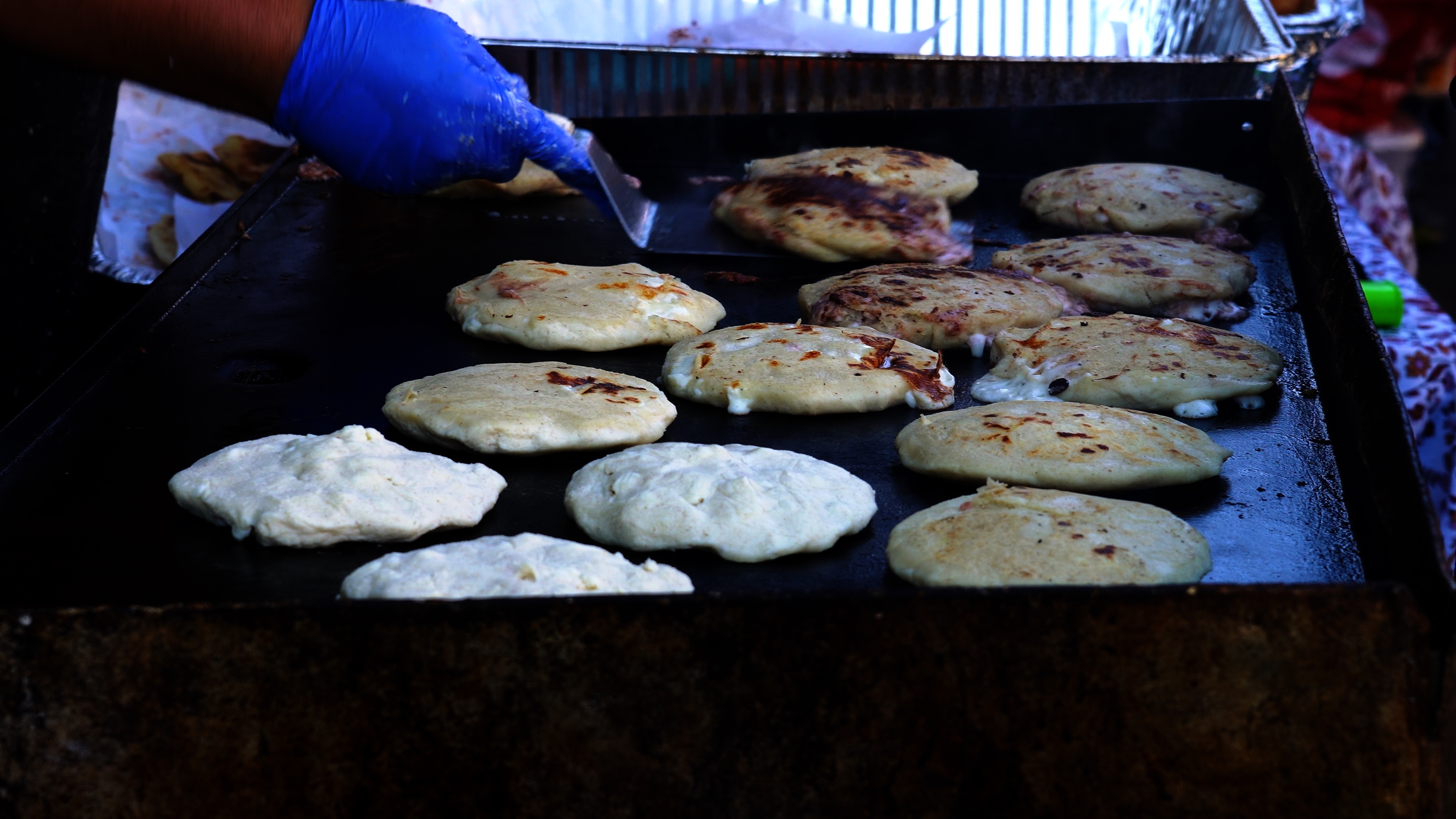 Handmade pupusas cooking on the griddle