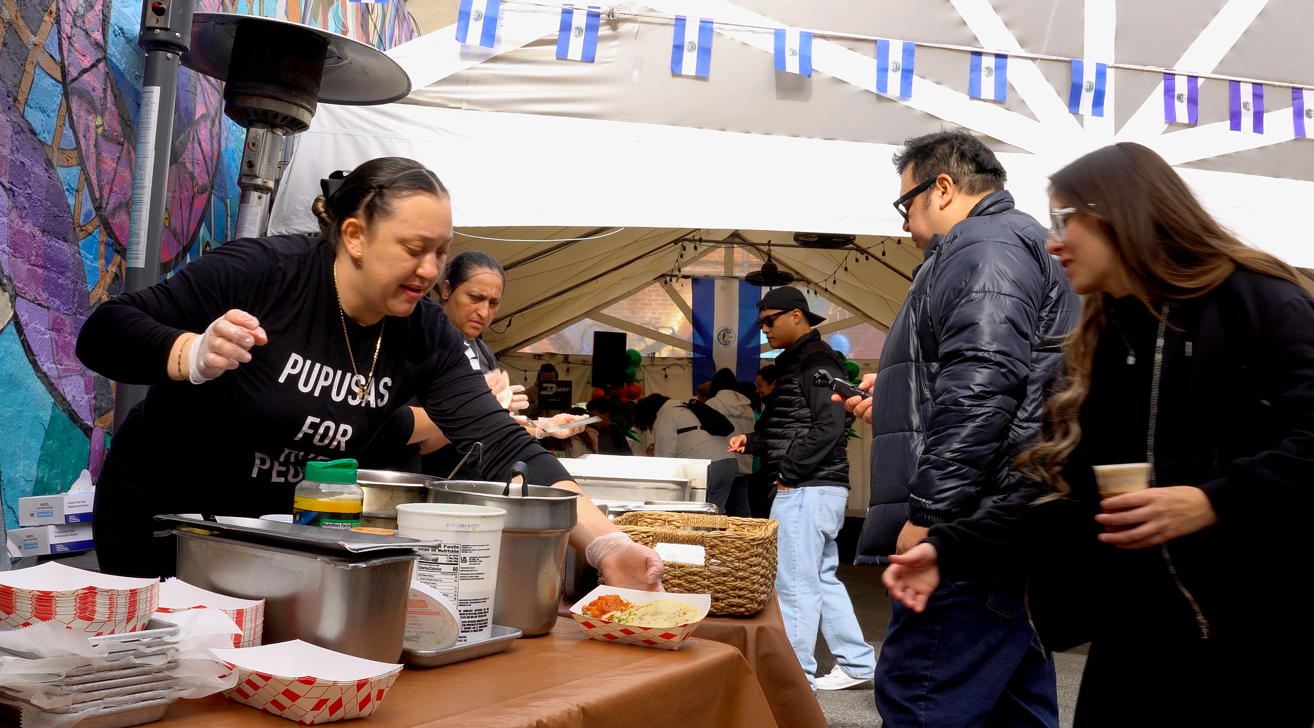 Serving pupusas at a community event