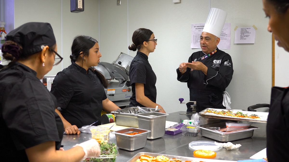 Chef Benjamín Velásquez working with his daughters and catering crew at Carlos Rosario School event